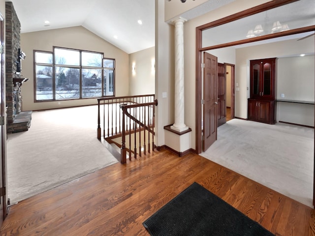 corridor with vaulted ceiling, carpet, an upstairs landing, and ornate columns