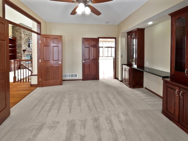 unfurnished room featuring a ceiling fan, visible vents, light carpet, and baseboards