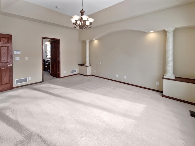 unfurnished room featuring visible vents, decorative columns, and light carpet