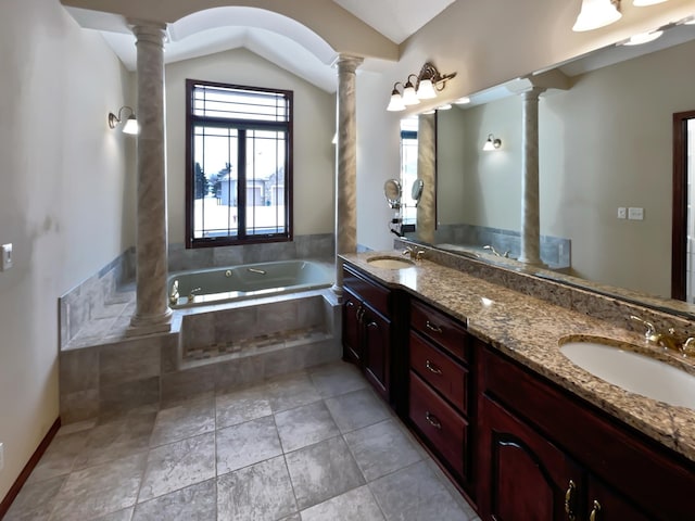 bathroom featuring vaulted ceiling, a sink, ornate columns, and a bath