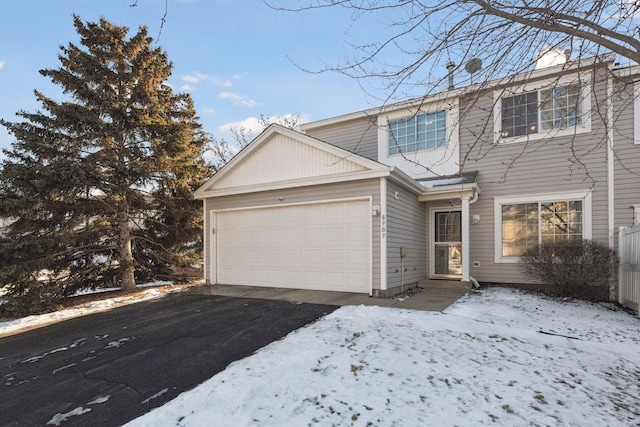 traditional-style house featuring aphalt driveway and an attached garage