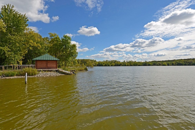 dock area featuring a wooded view and a water view