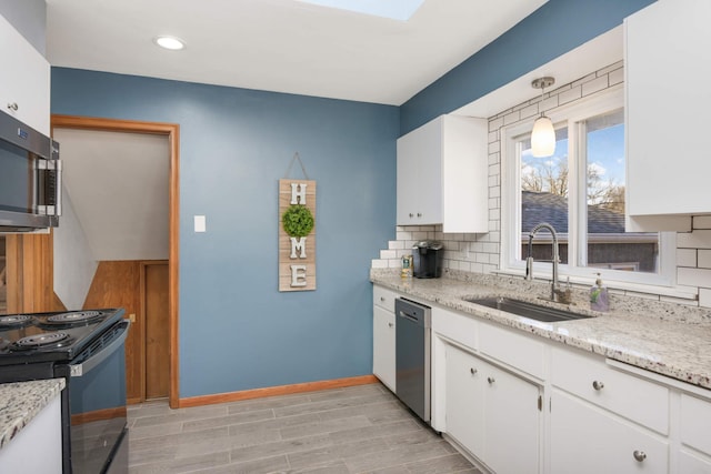 kitchen featuring stainless steel appliances, backsplash, a sink, and white cabinets