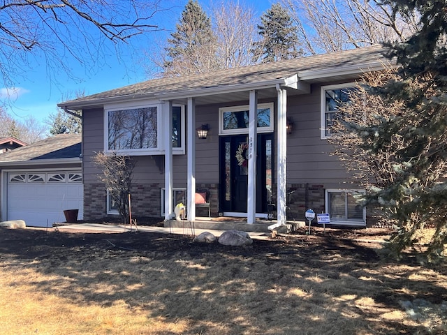 entrance to property with a garage and a shingled roof