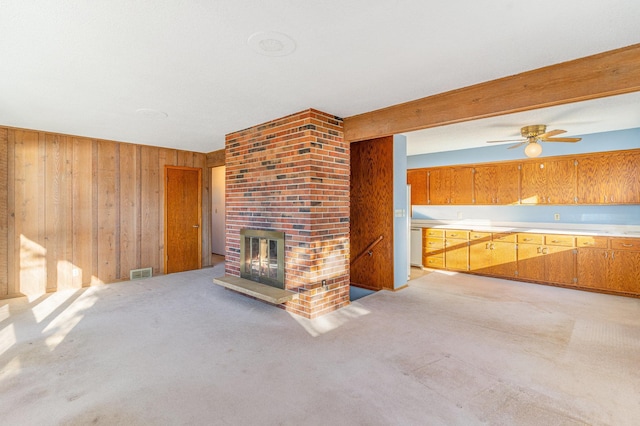 13197 132nd St W, Apple Valley, MN 55124 - unfurnished living room featuring wood walls, light colored carpet, a ceiling fan, and a brick fireplace