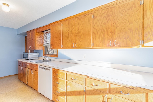 13197 132nd St W, Apple Valley, MN 55124 - kitchen featuring dishwasher, stainless steel microwave, a sink, light countertops, and brown cabinets