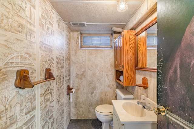 13197 132nd St W, Apple Valley, MN 55124 - bathroom featuring toilet, a textured ceiling, vanity, and wood walls
