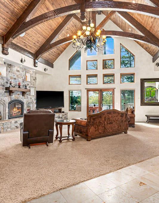 living room with wood ceiling, a fireplace, high vaulted ceiling, and beam ceiling