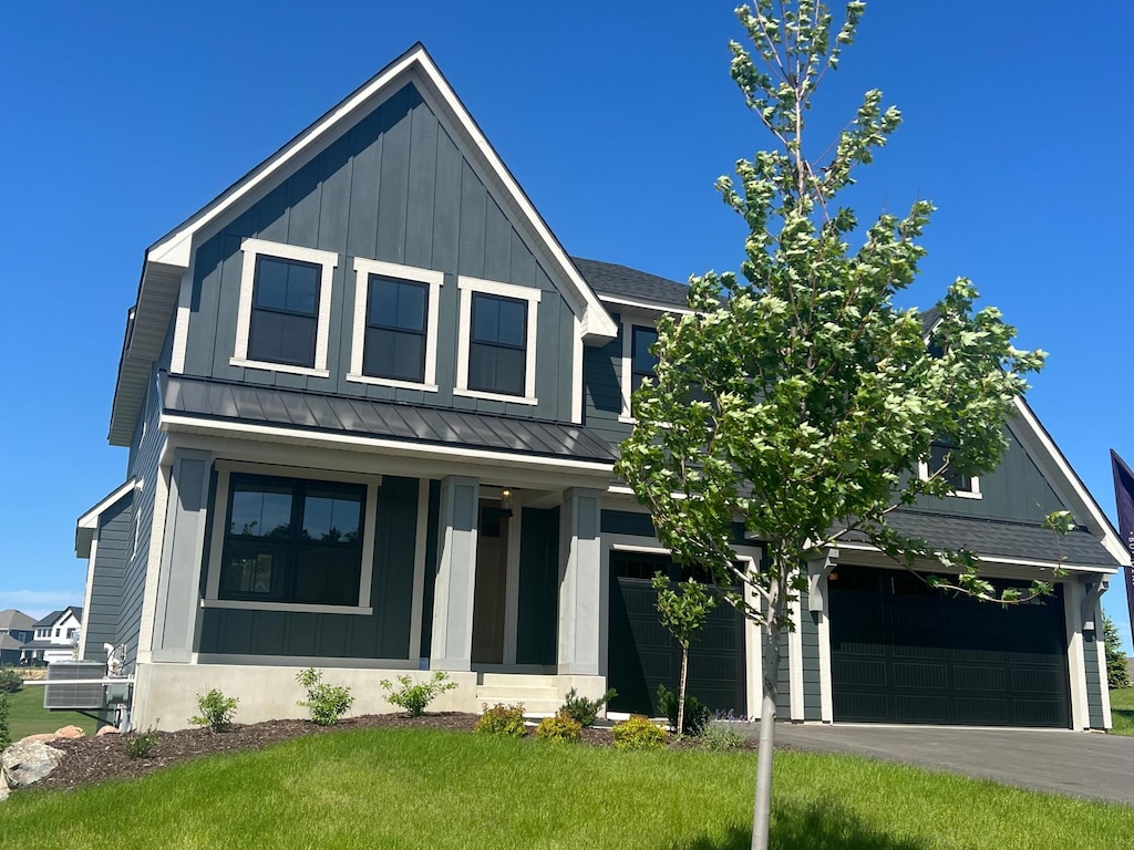 modern farmhouse style home featuring a standing seam roof, metal roof, a shingled roof, and board and batten siding