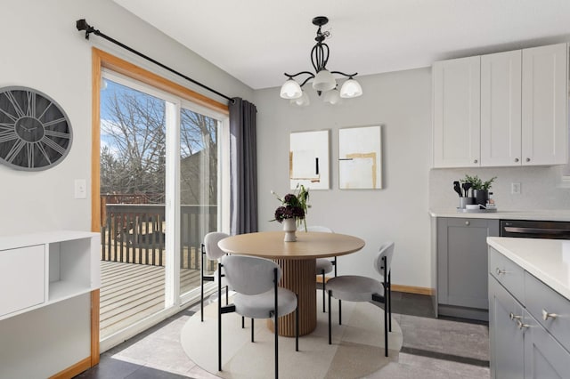 dining room featuring a notable chandelier and baseboards