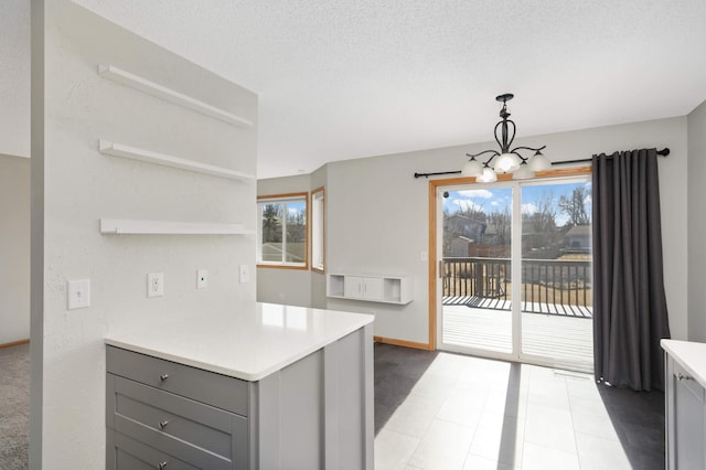 kitchen with pendant lighting, open shelves, light countertops, gray cabinetry, and a textured ceiling