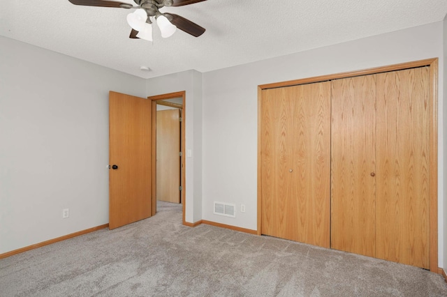 unfurnished bedroom with light carpet, a closet, a textured ceiling, and visible vents