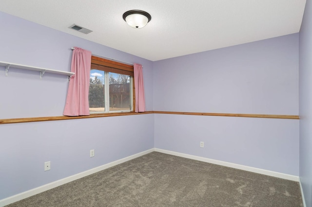 empty room featuring carpet, visible vents, a textured ceiling, and baseboards