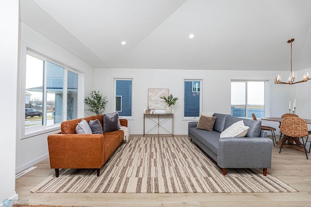 living area with a chandelier, a water view, baseboards, vaulted ceiling, and light wood-type flooring