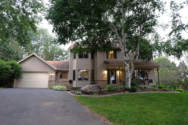 view of front of house featuring an attached garage, brick siding, driveway, and a front yard