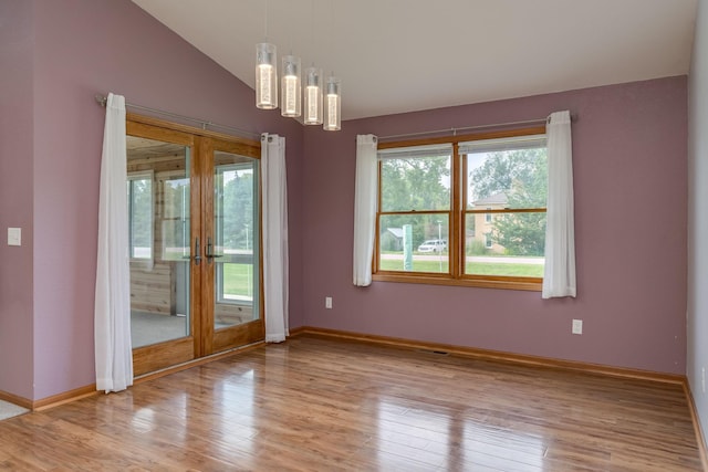 spare room with lofted ceiling, french doors, wood finished floors, and baseboards