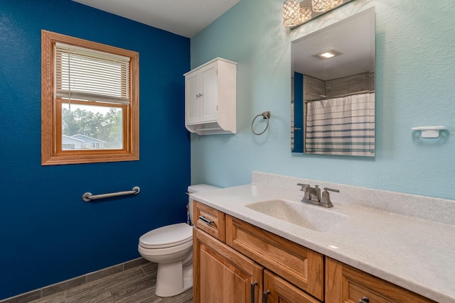 bathroom featuring toilet, vanity, wood finished floors, a shower with curtain, and baseboards