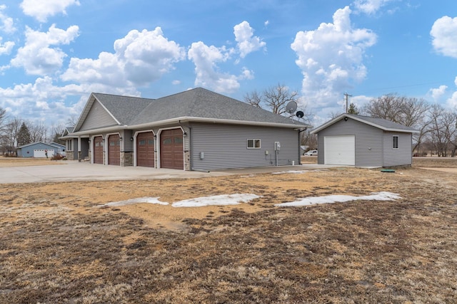 exterior space with a garage and an outbuilding