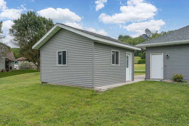 view of property exterior featuring a lawn and an outdoor structure