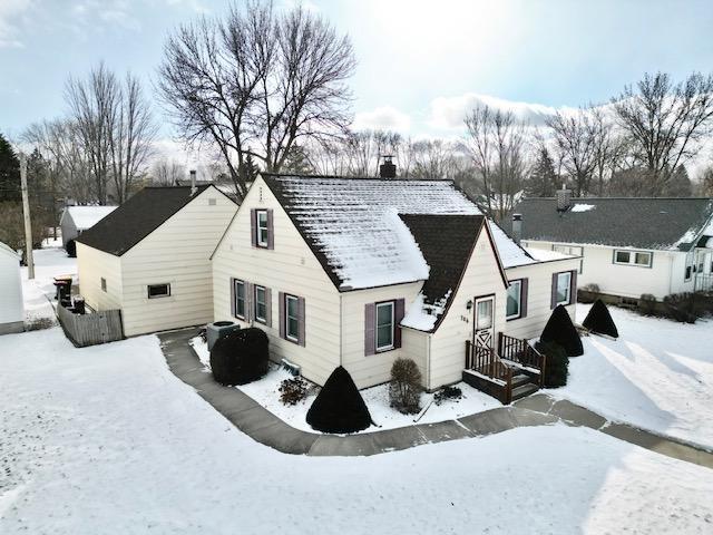 snow covered house with central air condition unit