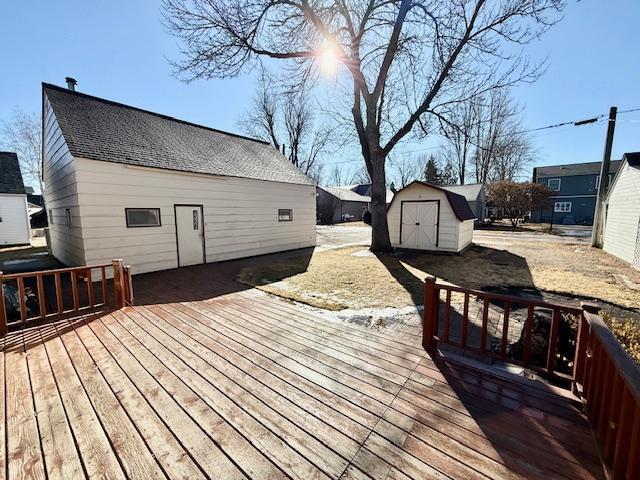 wooden terrace featuring an outbuilding and a shed