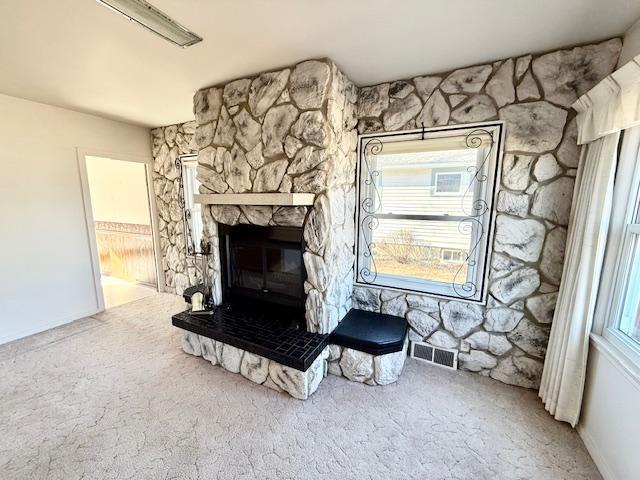 interior details with carpet, a fireplace, and visible vents