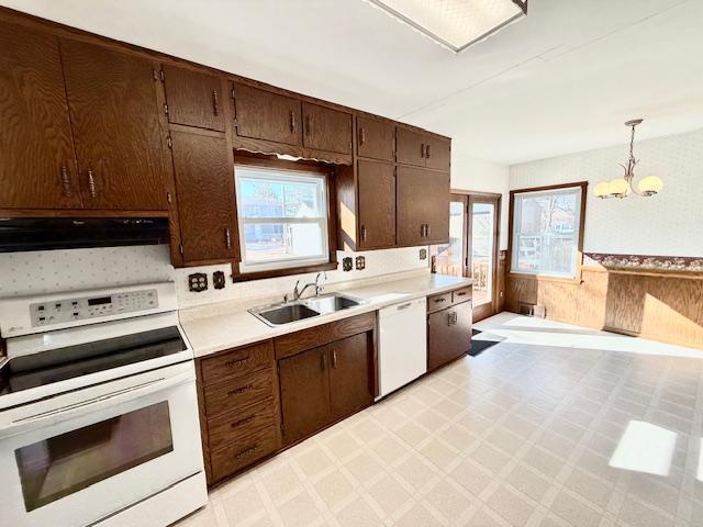 kitchen with extractor fan, white appliances, a sink, light countertops, and light floors