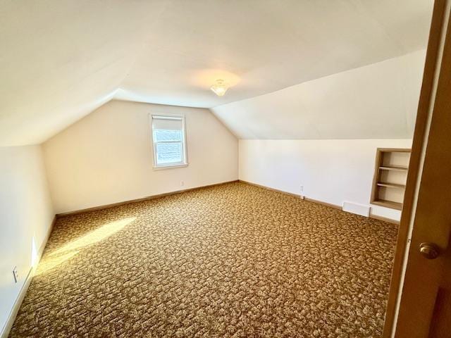 bonus room with lofted ceiling, carpet floors, and baseboards