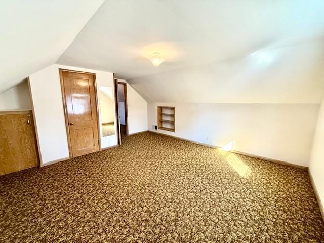 bonus room featuring lofted ceiling, baseboards, carpet floors, and built in features