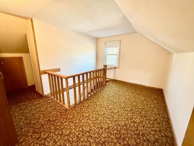 additional living space with vaulted ceiling and carpet