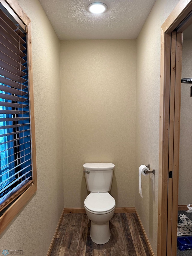 bathroom featuring a textured ceiling, wood finished floors, toilet, and baseboards