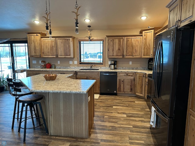 kitchen featuring dark wood-style floors, freestanding refrigerator, a sink, dishwasher, and a kitchen bar