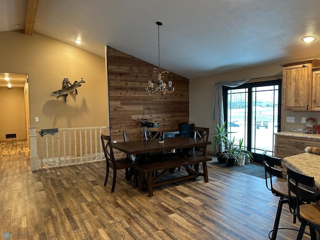 dining room with lofted ceiling with beams, a notable chandelier, visible vents, and dark wood-style flooring