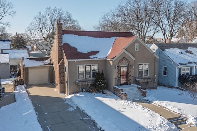 view of front of home featuring stucco siding, an outbuilding, a garage, and a chimney