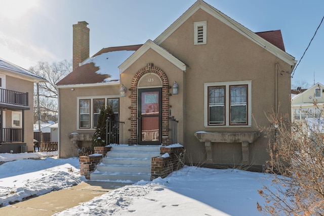 view of front of property with stucco siding and a chimney