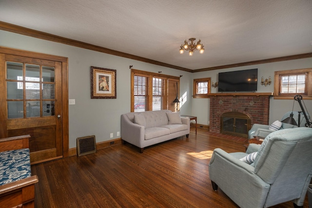 living area featuring wood finished floors, visible vents, baseboards, a fireplace, and ornamental molding