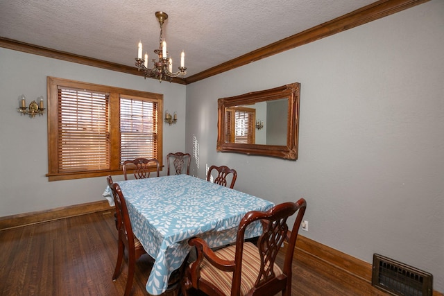 dining space featuring visible vents, crown molding, an inviting chandelier, wood finished floors, and a textured ceiling