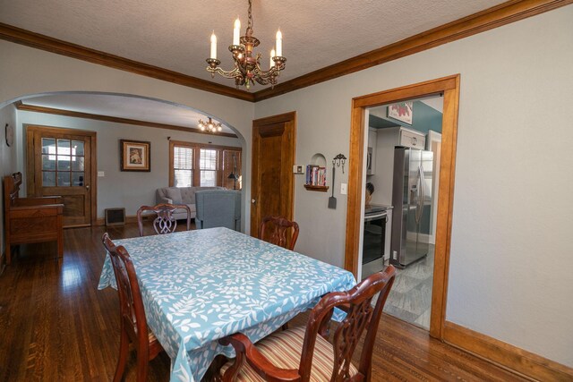 dining area with arched walkways, a chandelier, a textured ceiling, and dark wood-style floors