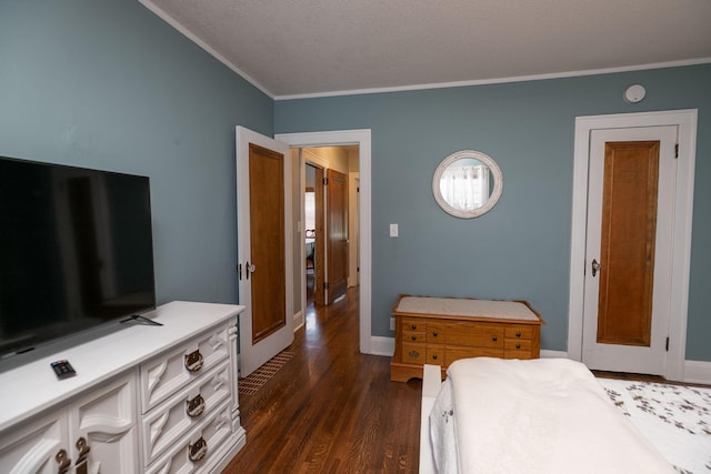 bedroom featuring crown molding, baseboards, dark wood-style flooring, and a textured ceiling