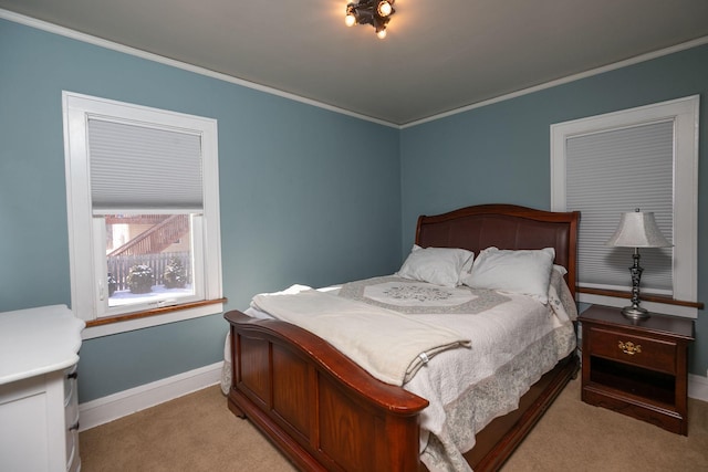 bedroom featuring baseboards, crown molding, and carpet