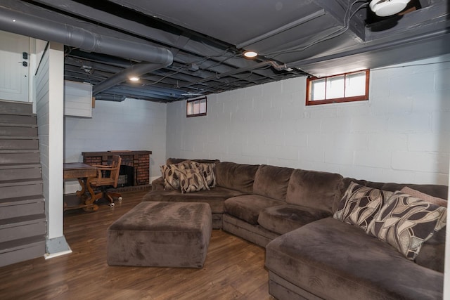 living room featuring dark wood-type flooring, stairway, and a fireplace