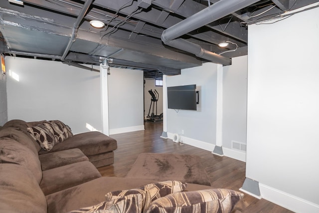 living room featuring wood finished floors, visible vents, and baseboards