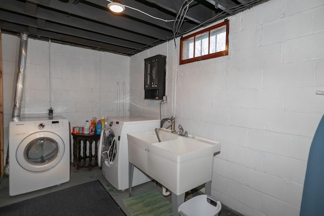 clothes washing area with washer and clothes dryer, laundry area, and a sink