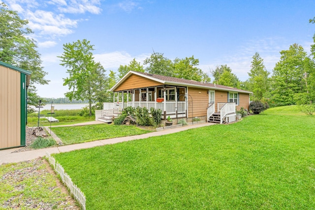 view of front of house with a porch, a water view, and a front lawn