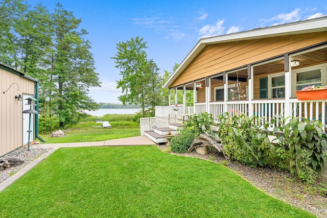 view of yard with covered porch and a water view