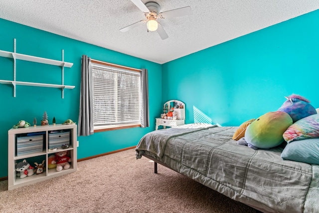 carpeted bedroom with a textured ceiling, a ceiling fan, and baseboards