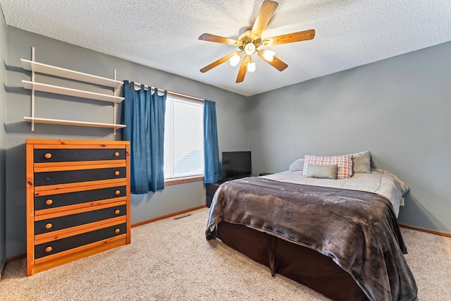 carpeted bedroom with visible vents, ceiling fan, a textured ceiling, and baseboards