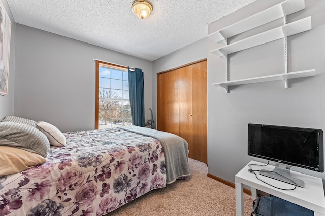 bedroom featuring light carpet, a textured ceiling, baseboards, and a closet