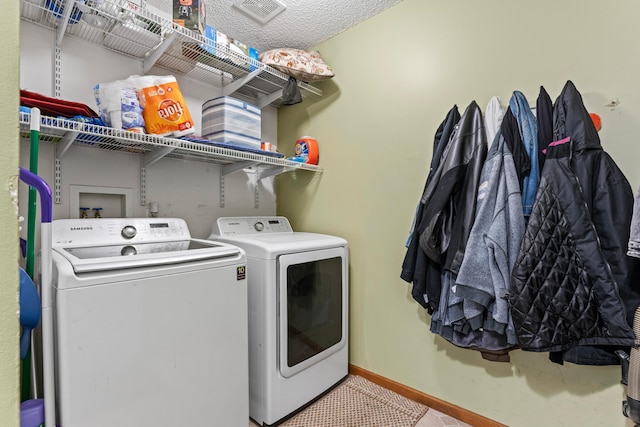 clothes washing area featuring washing machine and dryer, laundry area, and baseboards