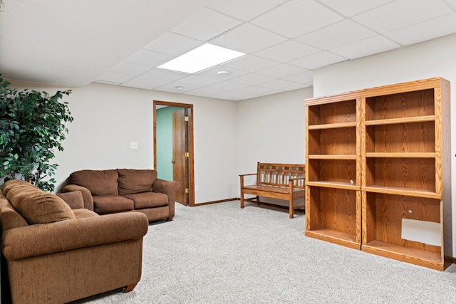 carpeted living room featuring a paneled ceiling and baseboards